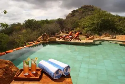 Infinity pool carved into the rock at Elsa’s Kopje, with a tray of drinks on the edge