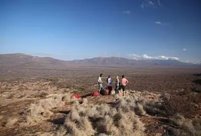 Guests gathered on a rocky ridge looking out over the Samburu plains