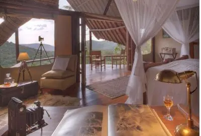 Tented suite interior with a four-poster bed and writing desk