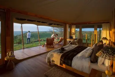 Tented bedroom at Loisaba with the front of the tent open to the plains