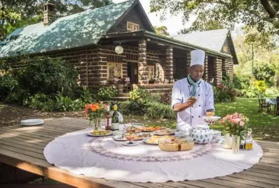Chef laying a garden lunch table outside the stone cottages of Loldia House
