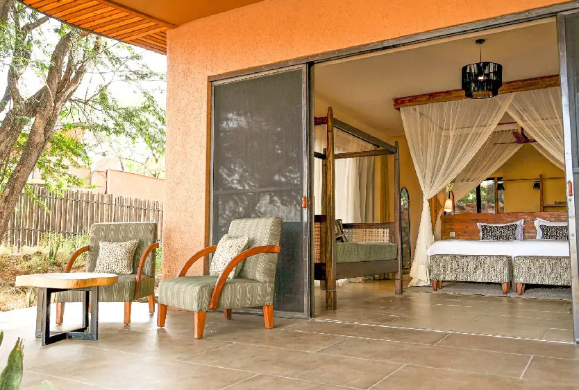 Shaded veranda opening onto a four-poster bed in a room at Soroi Samburu
