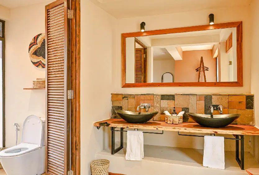 Twin stone basins beneath a timber-framed mirror in a Soroi Samburu bathroom