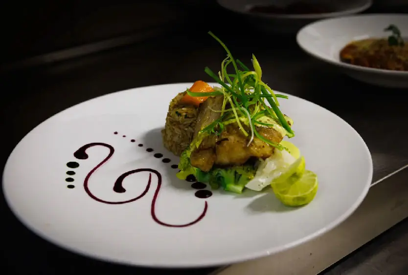 Plated fish with greens on a white dish at Soroi Blue