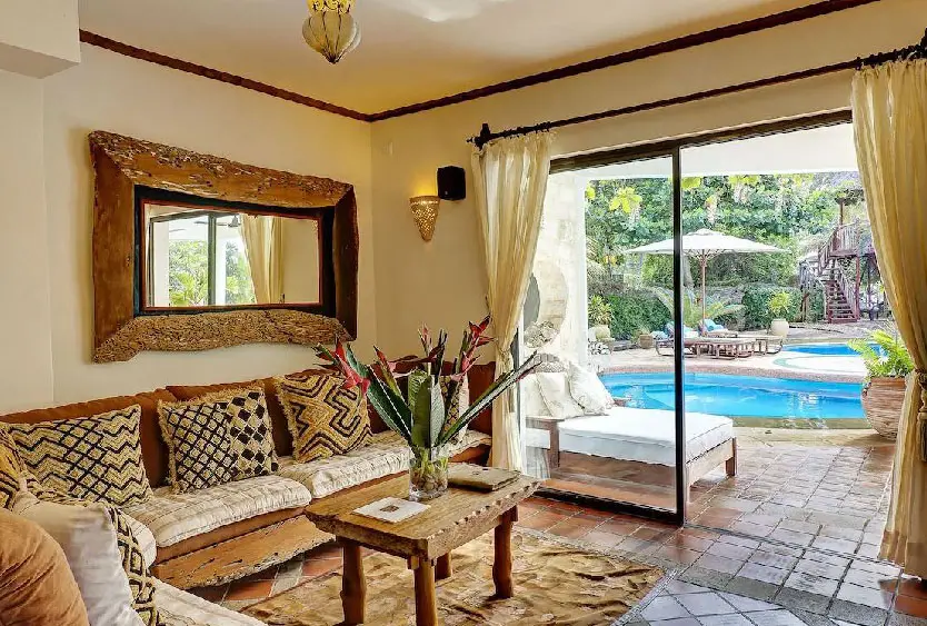 Sitting room at Soroi Blue opening through glass doors onto the pool garden