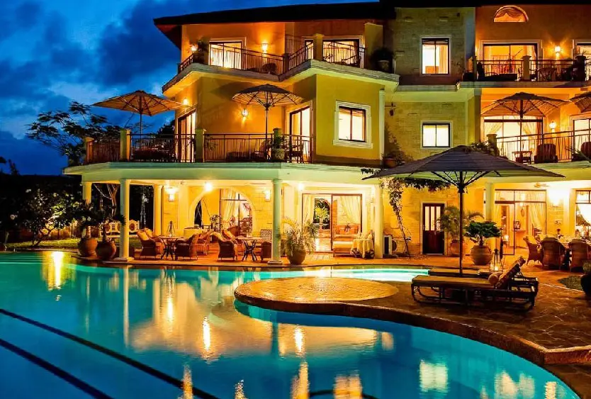 Soroi Blue lit up at dusk above its curved swimming pool