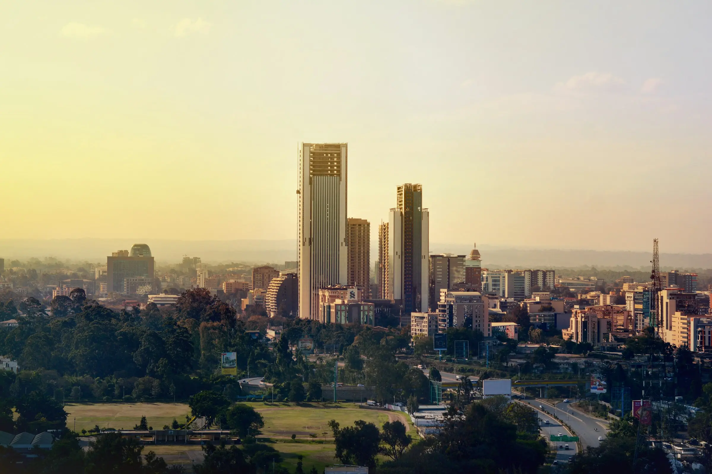 Nairobi's towers rising above green suburbs in the golden haze of late afternoon