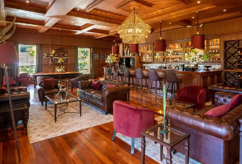 Timber-panelled lounge bar with leather sofas and a chandelier