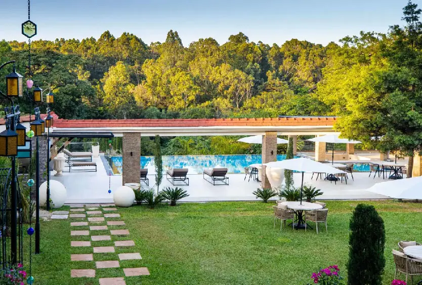 Stepping stones across a manicured lawn leading to the poolside terrace
