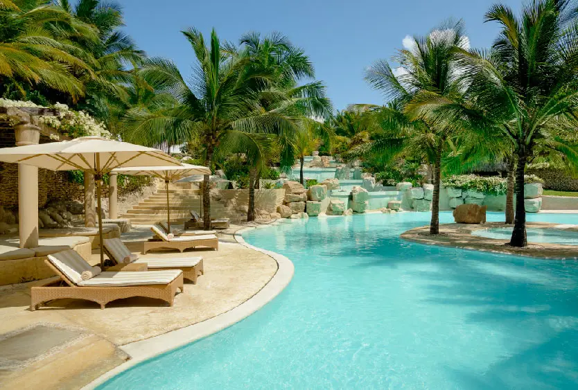 Palm-fringed swimming pool and sun loungers at the Diani beach resort